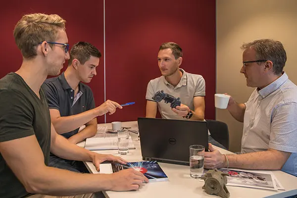 Engineering-Besprechung mit vier Mitarbeitenden